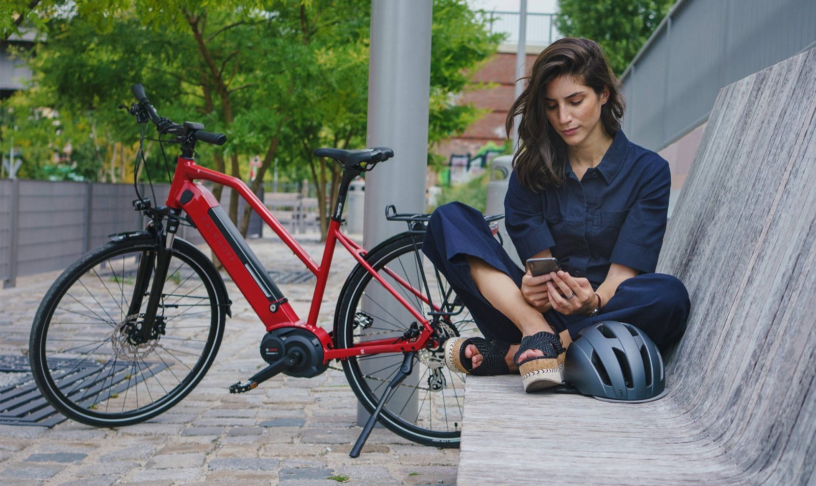 Frau mit rotem City-E-Bike