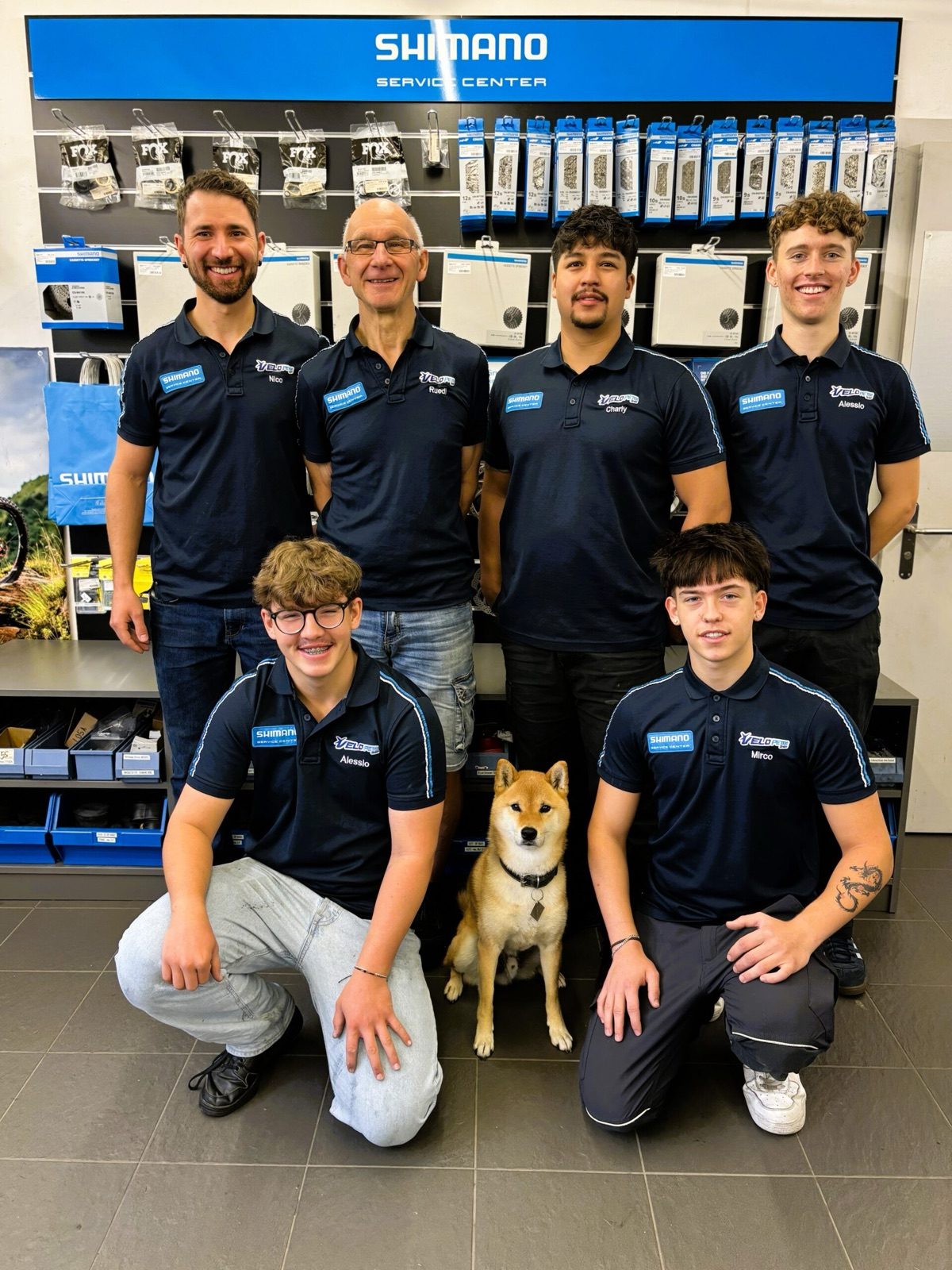 Das Team von Velo Peter mit Hund Akio in der Werkstatt
